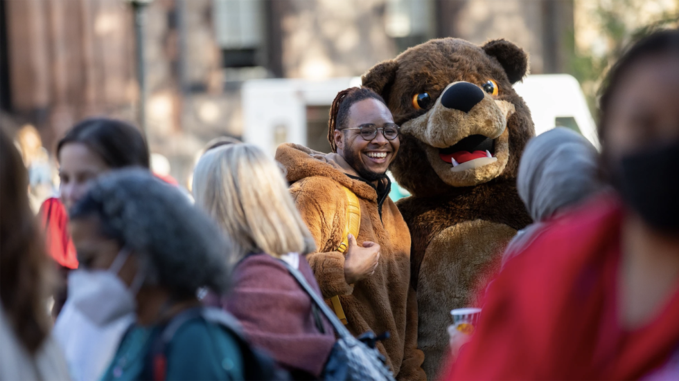 a man posing with the Brown mascot